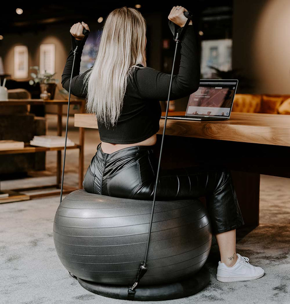 exercise with pilates ball in the office woman